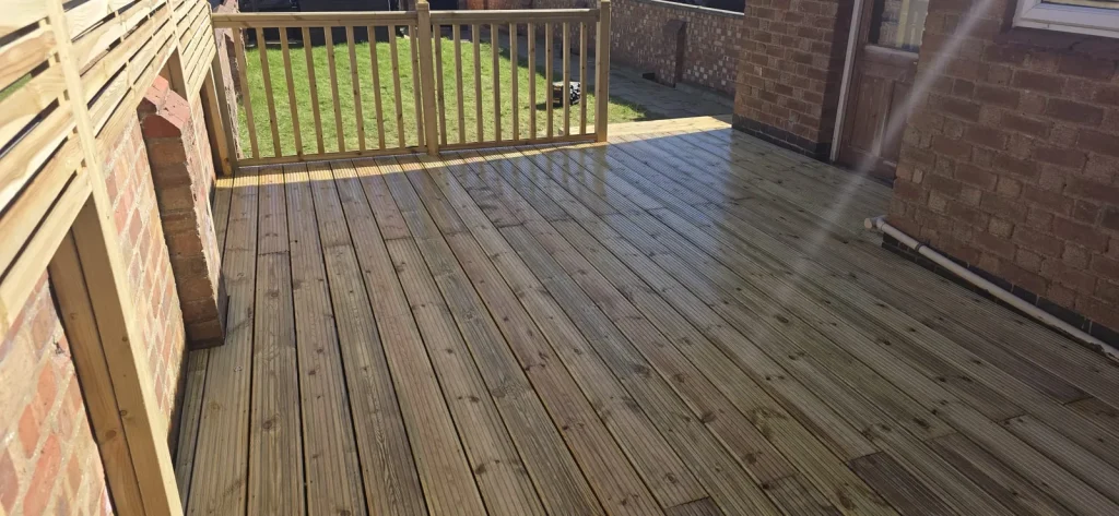 Timber decking with slatted privacy screens and a spindle balustrade in Abington, Northampton